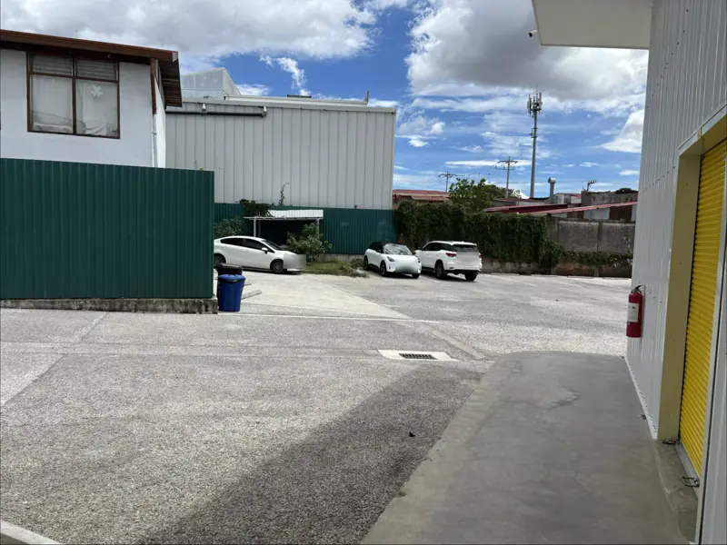 La entrada de vehículos y el área de parqueo, al costado de las bodegas.