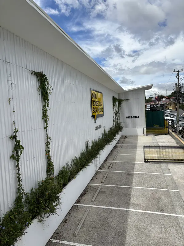 La fachada sobre la calle, con el rótulo de Mini Bodegas San Pedro y el parqueo de visitas.